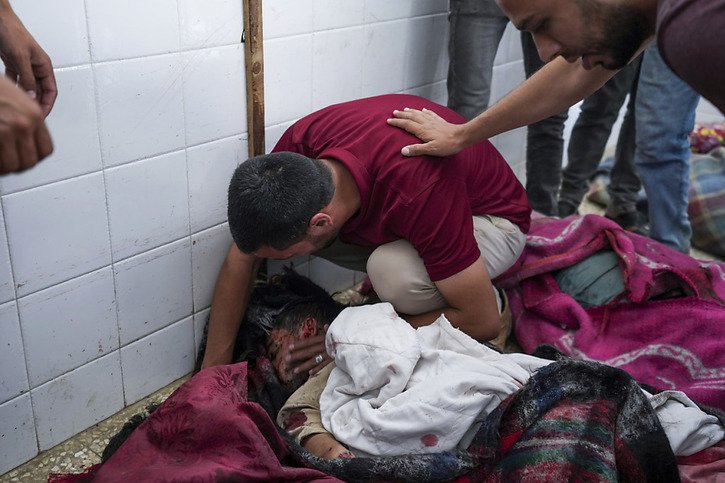 Des Palestiniens pleurent leurs proches tués dans les bombardements israéliens. © KEYSTONE/AP/Abdel Kareem Hana