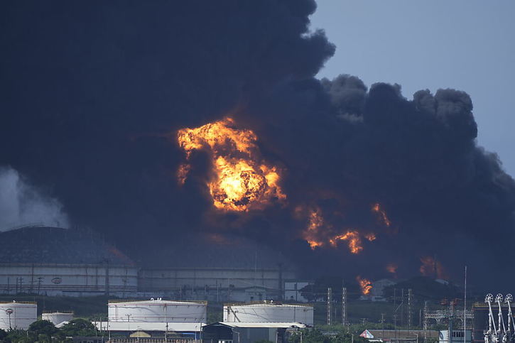 L'incendie s'est déclaré vendredi soir quand la foudre a frappé l'un des réservoirs du dépôt pétrolier. Au petit matin, le feu s'est ensuite propagé à un deuxième réservoir. © KEYSTONE/AP/Ramon Espinosa