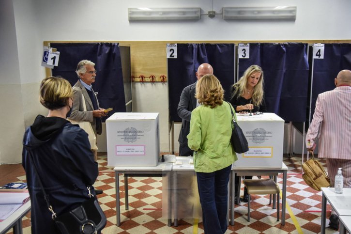 Des Italiens attendent de glisser leur bulletin dans l'urne dans un bureau de vote de Milan. © KEYSTONE/EPA/Matteo Corner