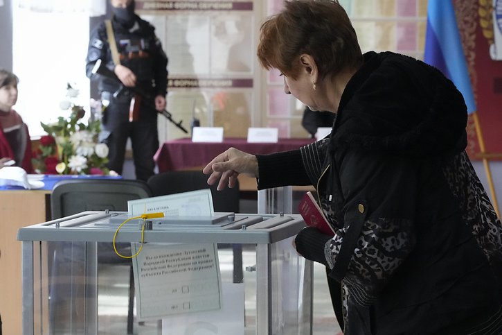 Une femme vote sur le rattachement à la Russie à Lougansk. © KEYSTONE/AP
